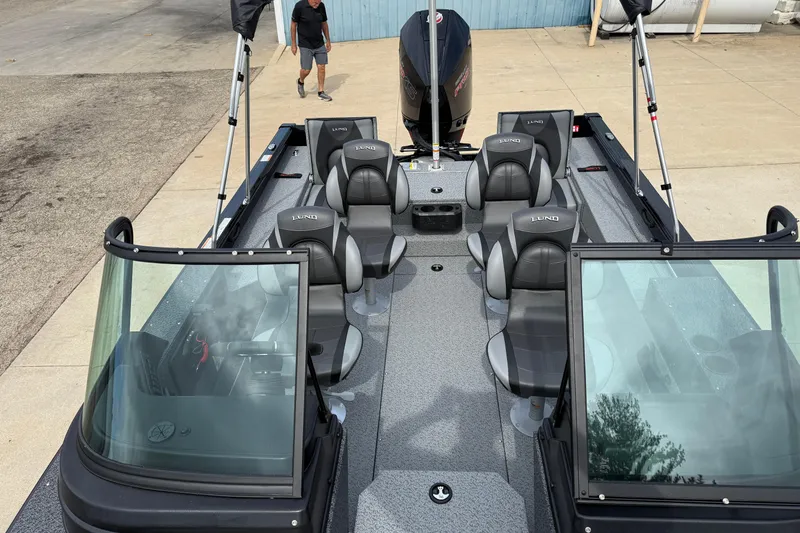 Slide: The Image of 2026 Lund 2075 Impact XS boat with seating and windshield, parked on concrete. - 15