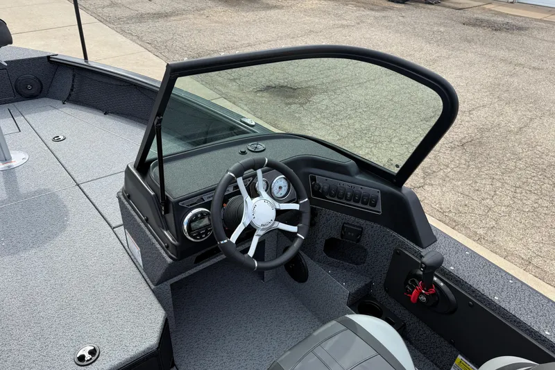 Slide: The Image of 2026 Lund 2075 Impact XS boat cockpit with steering wheel and dashboard controls. - 19