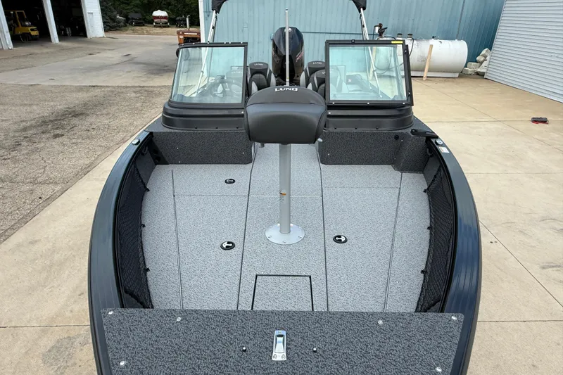 Slide: The Image of 2026 Lund 2075 Impact XS boat, spacious interior, dual windshields, docked outdoors. - 8