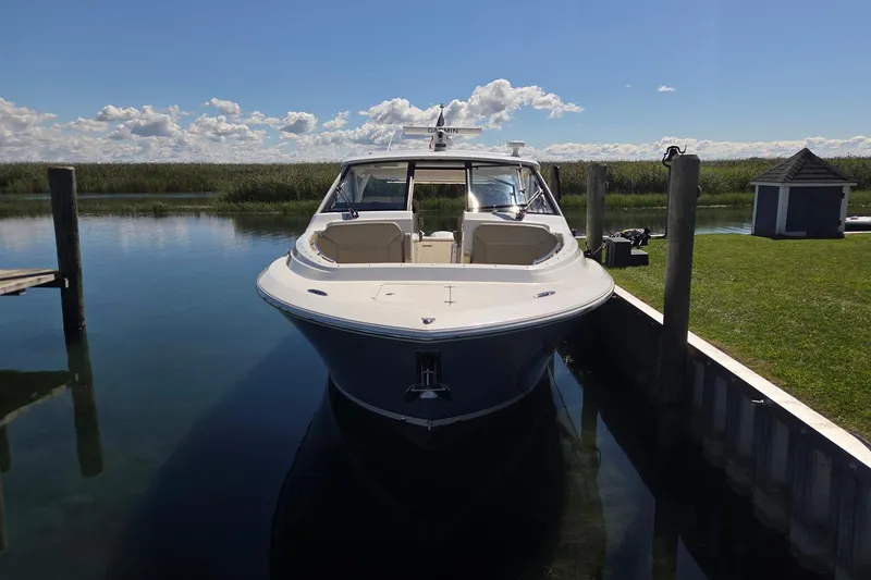 Slide: The Image of 2020 Pursuit DC 365 Dual Console boat docked in serene waters. - 12
