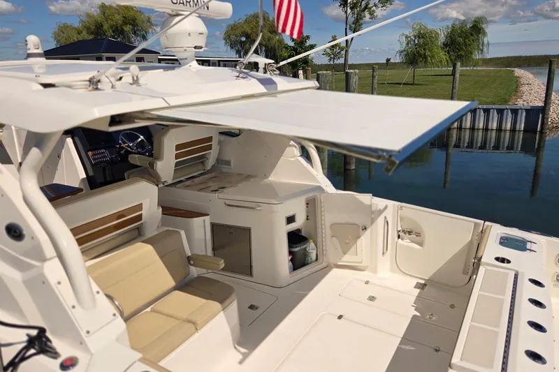 Slide: The Image of 2020 Pursuit DC 365 Dual Console boat interior with seating and open storage compartments. - 15