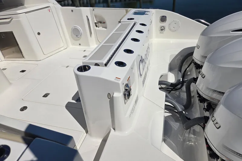 Slide: The Image of 2020 Pursuit DC 365 Dual Console boat deck with outboard engines and storage compartments. - 16