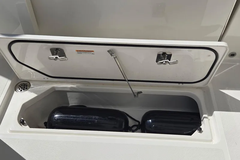 Slide: The Image of Storage compartment on 2020 Pursuit DC 365 Dual Console boat, featuring fenders inside. - 22
