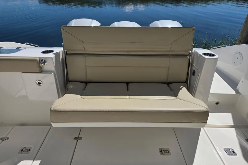 Slide: The Image of 2020 Pursuit DC 365 Dual Console boat with beige seating, docked by calm water. - 30