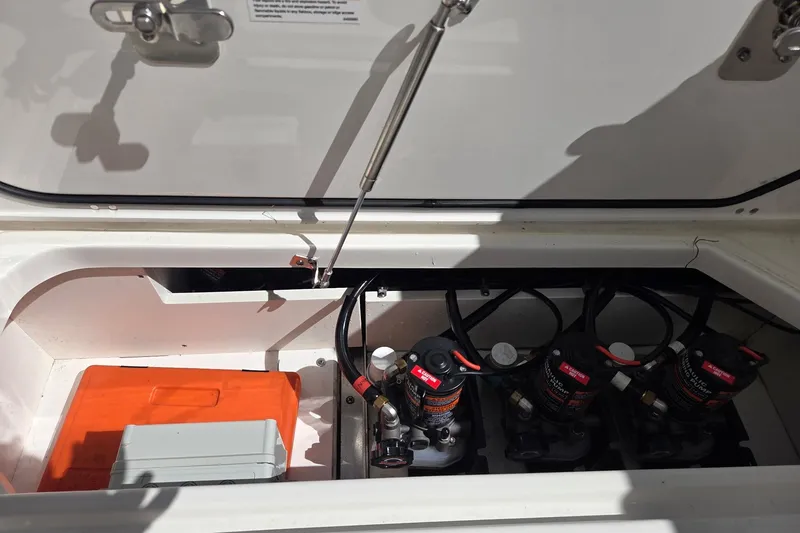 Slide: The Image of 2020 Pursuit DC 365 Dual Console storage compartment with pumps and equipment. - 31