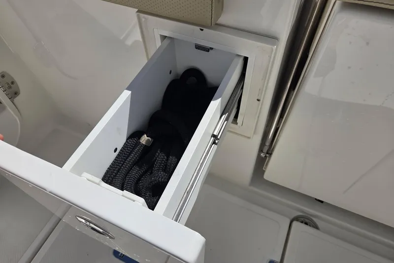 Slide: The Image of Storage compartment with rope on a 2020 Pursuit DC 365 Dual Console boat. - 35