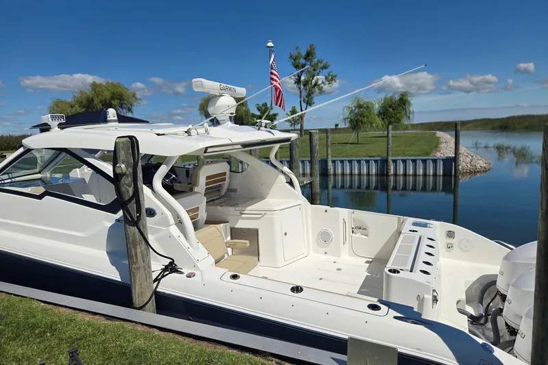 Slide: The Image of 2020 Pursuit DC 365 Dual Console boat docked by a serene lake. - 4