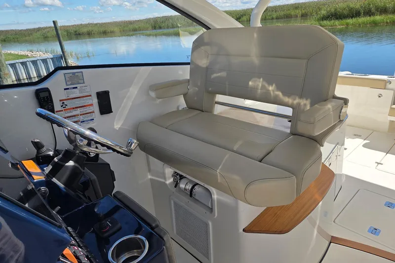 Slide: The Image of 2020 Pursuit DC 365 Dual Console helm with beige seating and scenic water view. - 43