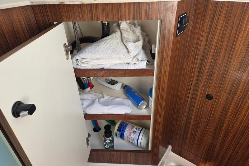 Slide: The Image of Open cabinet in 2020 Pursuit DC 365 Dual Console, storing towels and toiletries. - 48