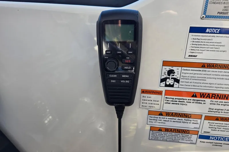 Slide: The Image of VHF marine radio on 2020 Pursuit DC 365 Dual Console with safety warning labels. - 51