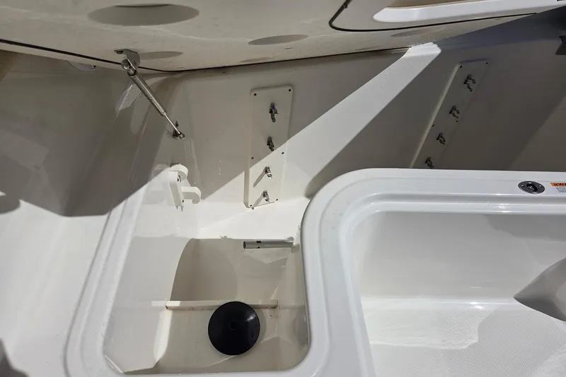 Slide: The Image of 2020 Pursuit DC 365 Dual Console interior storage compartment with white finish and hardware. - 58