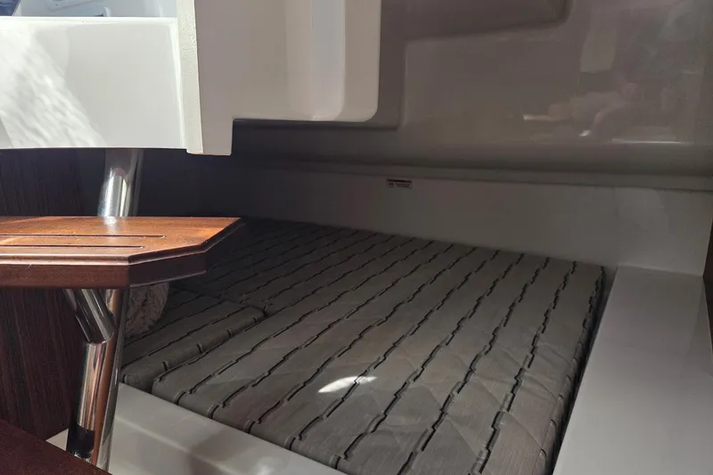 Slide: The Image of 2020 Pursuit DC 365 Dual Console interior cabin with wooden table and cushioned seating. - 64