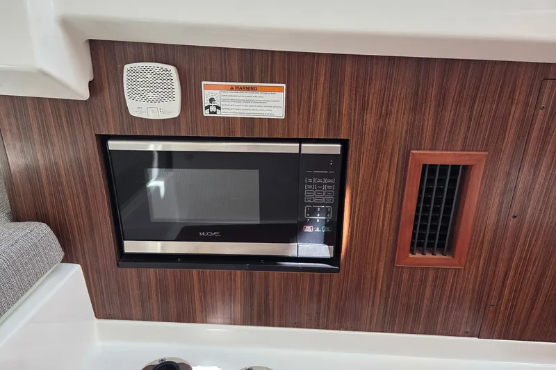 Slide: The Image of 2020 Pursuit DC 365 Dual Console interior with microwave and wood paneling. - 69