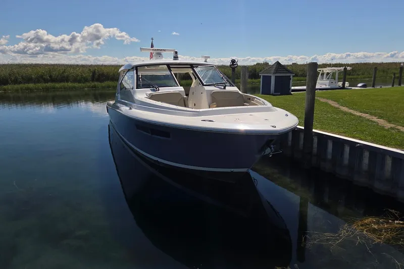 Slide: The Image of 2020 Pursuit DC 365 Dual Console boat docked on a sunny day. - 7