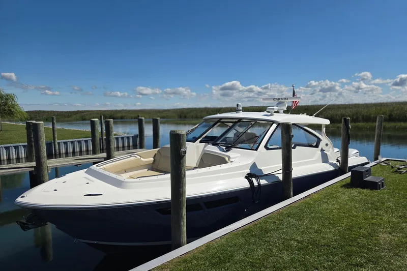 Slide: The Image of 2020 Pursuit DC 365 Dual Console boat docked on a sunny day. - 8