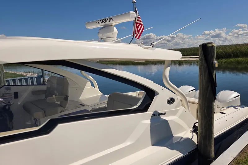 Slide: The Image of 2020 Pursuit DC 365 Dual Console boat docked on a sunny day with American flag. - 9