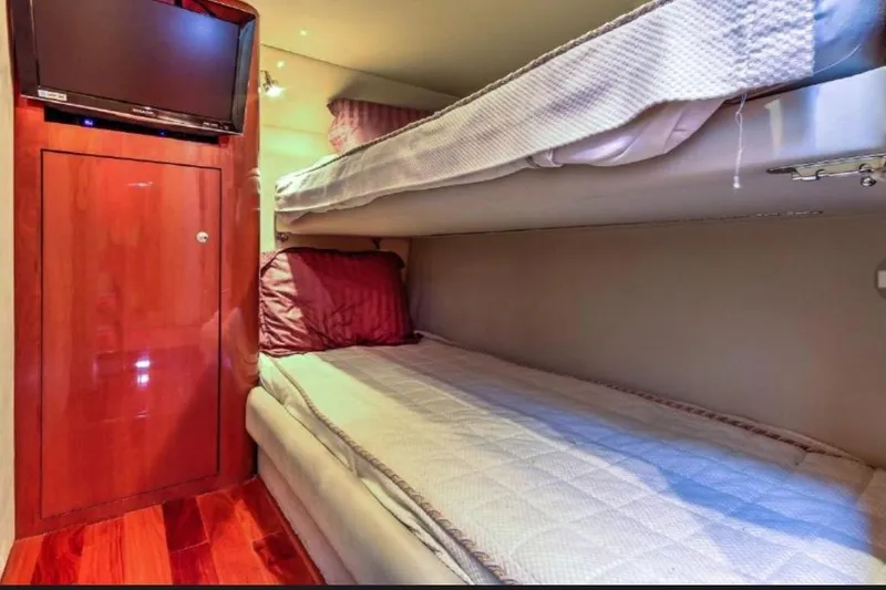 Slide: The Image of Bunk beds in 2002 Sea Ray 550 Sedan Bridge cabin with TV and wooden cabinetry. - 14