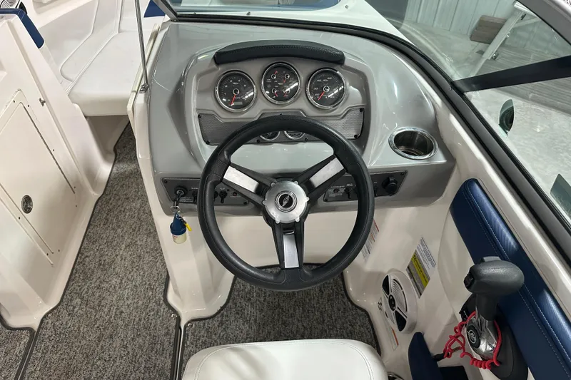 Slide: The Image of 2018 Chaparral 21 H2O Sport boat dashboard with steering wheel and control panel. - 9