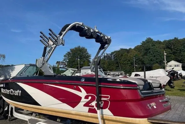 Slide: The Image of 2013 MasterCraft X-25 boat interior with red and white seating, modern dashboard, and steering wheel. - 13