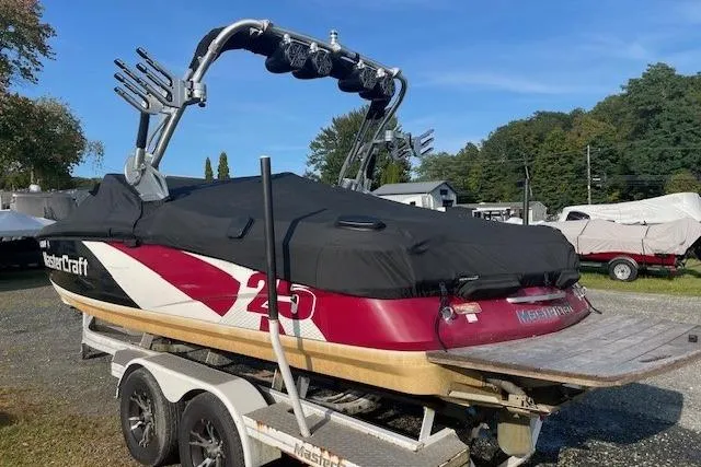 Slide: The Image of 2013 MasterCraft X-25 boat on trailer with cover, parked outdoors. - 18