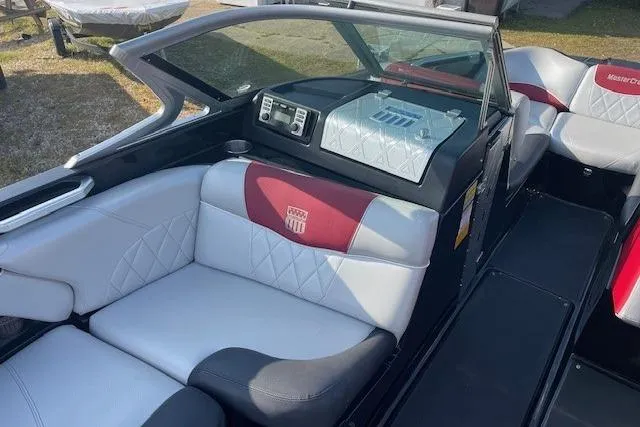 Slide: The Image of 2013 MasterCraft X-25 boat interior with red and white seating, modern dashboard, and steering wheel. - 2