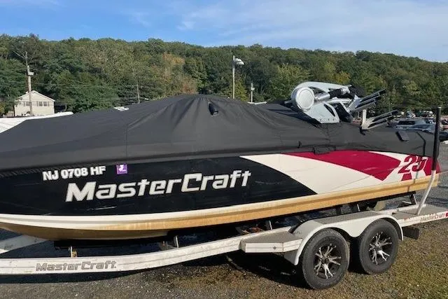Slide: The Image of 2013 MasterCraft X-25 boat on trailer, covered, parked outdoors. - 23