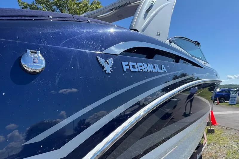 Slide: The Image of 2015 Formula 310 Bowrider boat with sleek blue exterior and logo detail. - 2