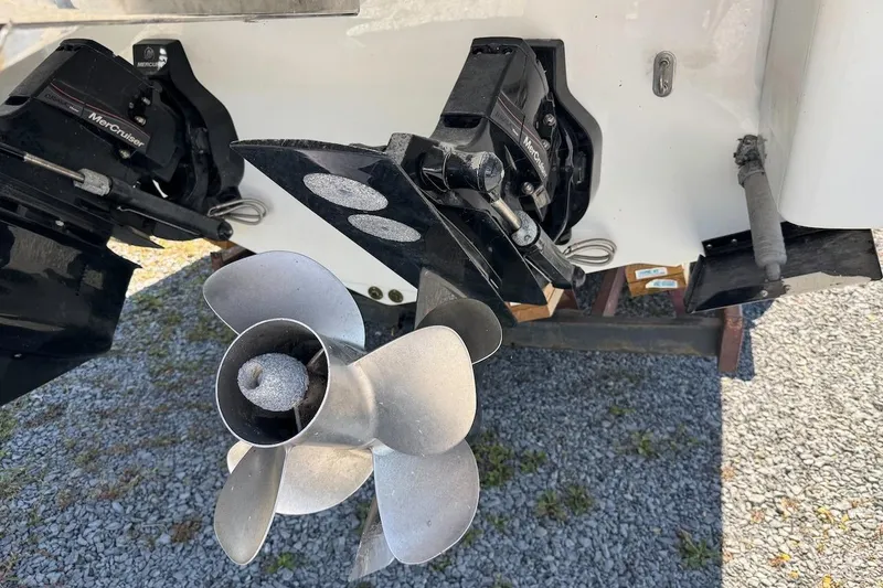 Slide: The Image of 2015 Formula 310 Bowrider boat with MerCruiser outdrive and propeller on gravel surface. - 4