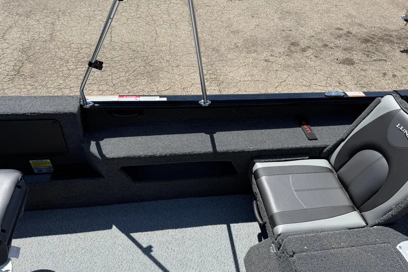 Slide: The Image of 2026 Lund 1875 Impact XS Sport boat interior with gray seating and carpeted flooring. - 24