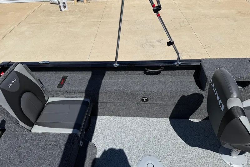 Slide: The Image of 2026 Lund 1875 Impact XS Sport boat interior with gray seating and storage compartments. - 25