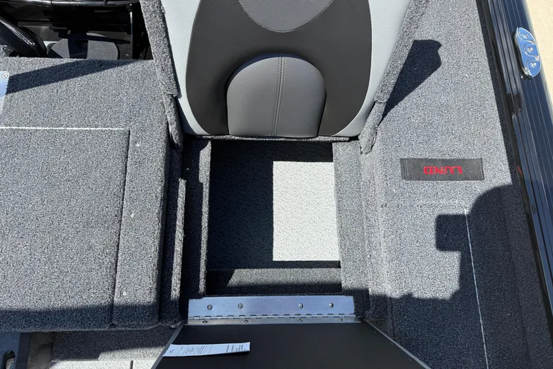 Slide: The Image of 2026 Lund 1875 Impact XS Sport boat interior with gray seating and carpeted flooring. - 28