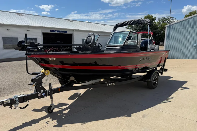 Slide: The Image of 2026 Lund 1875 Impact XS Sport boat on trailer outside showroom. - 4