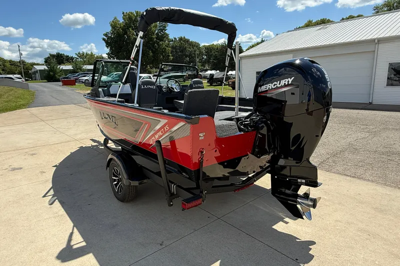 Slide: The Image of 2026 Lund 1875 Impact XS Sport boat with Mercury engine, parked outdoors. - 6