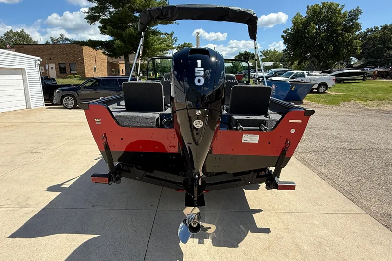 Slide: The Image of 2026 Lund 1875 Impact XS Sport boat with 150 HP engine, parked outdoors. - 7