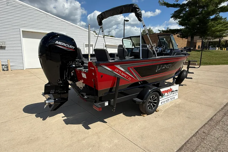 Slide: The Image of 2026 Lund 1875 Impact XS Sport boat with Mercury engine on a trailer, outdoors. - 8
