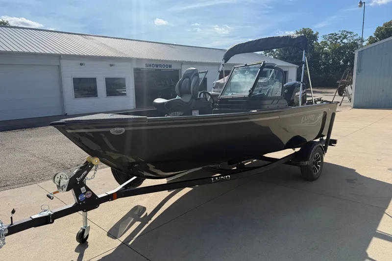 Slide: The Image of 2026 Lund 1650 Rebel XL Sport boat on trailer outside showroom. - 2