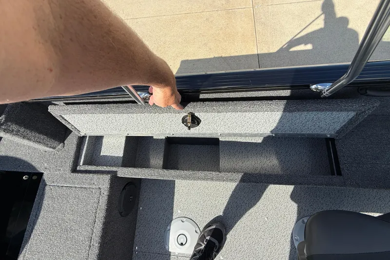 Slide: The Image of Open storage compartment in 2026 Lund 1650 Rebel XL Sport boat, showing battery and wiring. - 20