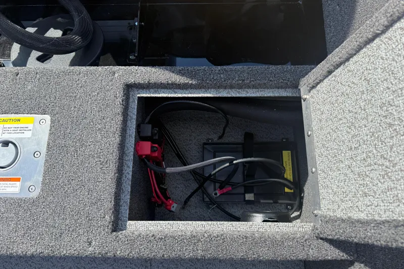 Slide: The Image of Open storage compartment in 2026 Lund 1650 Rebel XL Sport boat, featuring carpeted interior. - 21