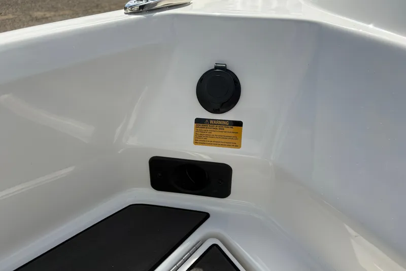 Slide: The Image of 2026 Lund 185 Impact GL boat interior detail with warning label and plug socket. - 13