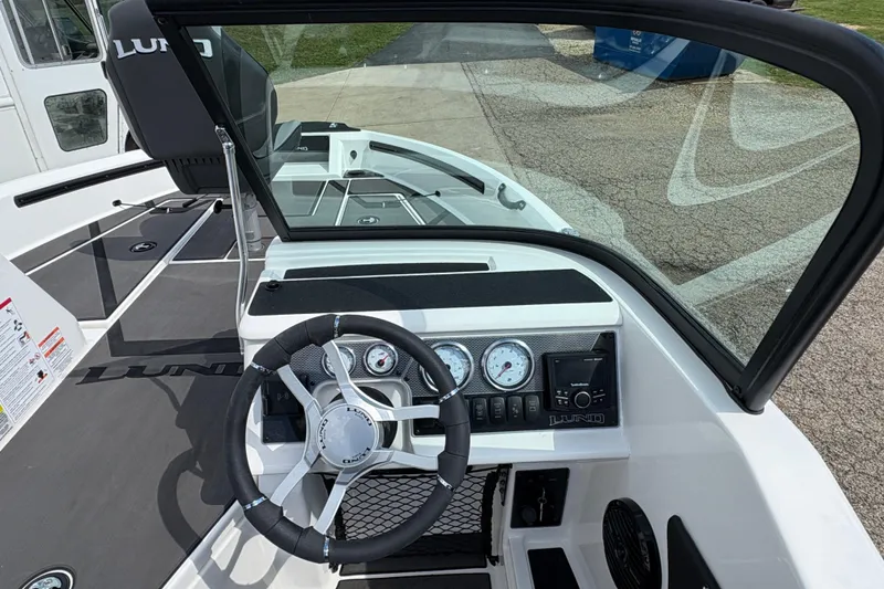 Slide: The Image of 2026 Lund 185 Impact GL boat dashboard with steering wheel and gauges. - 18