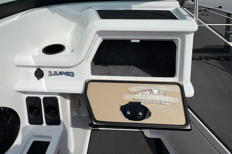 Slide: The Image of 2026 Lund 185 Impact GL boat interior with storage compartment and cup holder. - 20