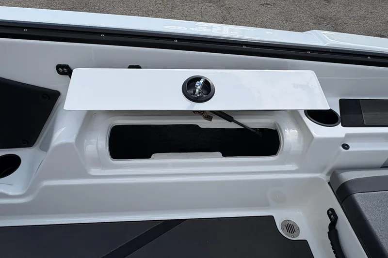 Slide: The Image of 2026 Lund 185 Impact GL boat storage compartment with open hatch and cup holder. - 22