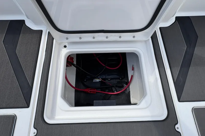Slide: The Image of Open storage compartment in 2026 Lund 185 Impact GL boat, showing battery and wiring. - 27