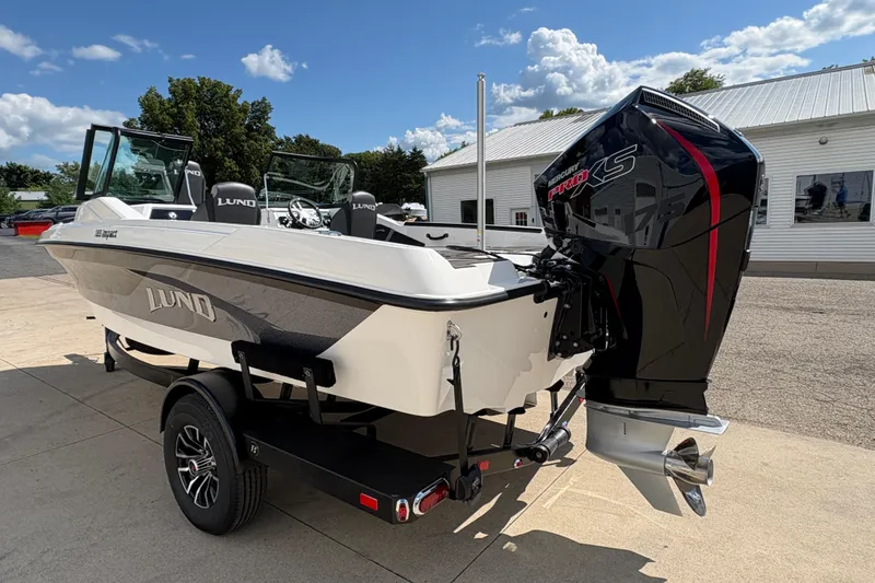 Slide: The Image of 2026 Lund 185 Impact GL boat with Mercury Pro XS engine, parked outdoors under a clear sky. - 3
