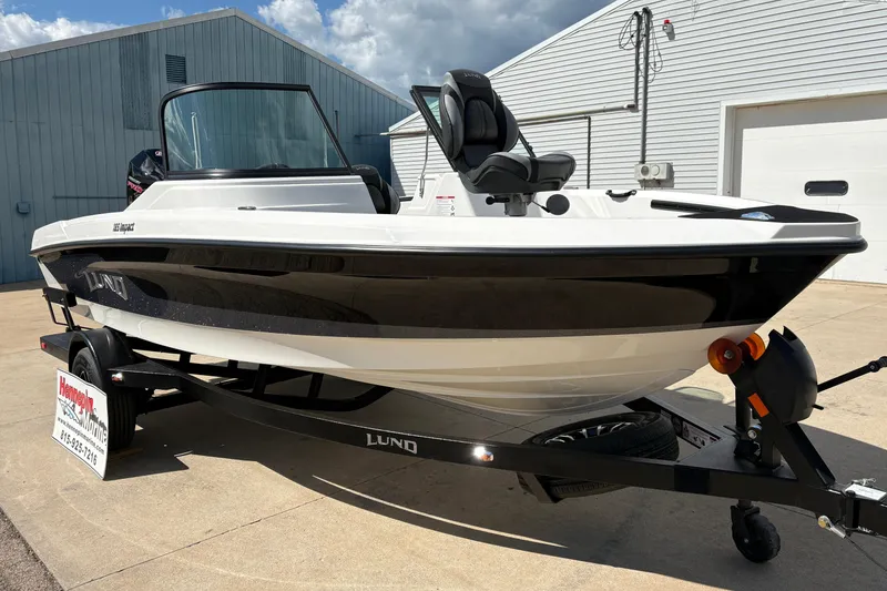 Slide: The Image of 2026 Lund 185 Impact GL boat on trailer, parked outdoors near a building. - 7