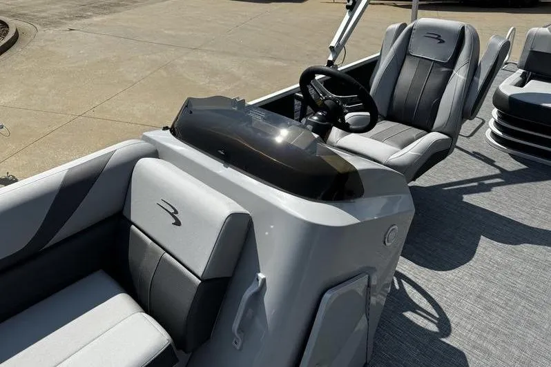 Slide: The Image of 2025 Bennington 25 SXSB boat interior with sleek seating and modern steering console. - 13