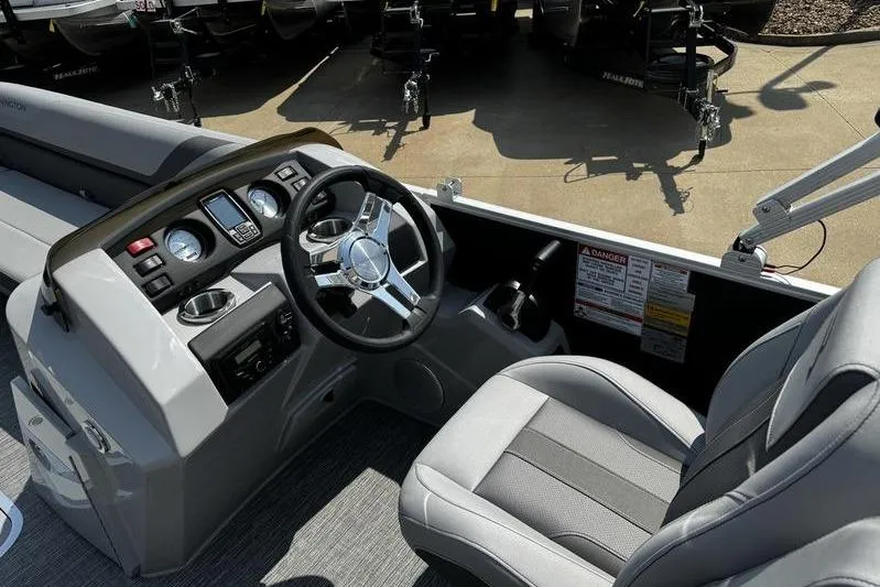 Slide: The Image of 2025 Bennington 25 SXSB boat interior with steering wheel and seating. - 15