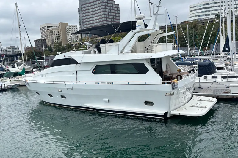 Slide: The Image of Luxury 1986 Maiora Phantom yacht docked in a marina, surrounded by cityscape and other boats. - 2