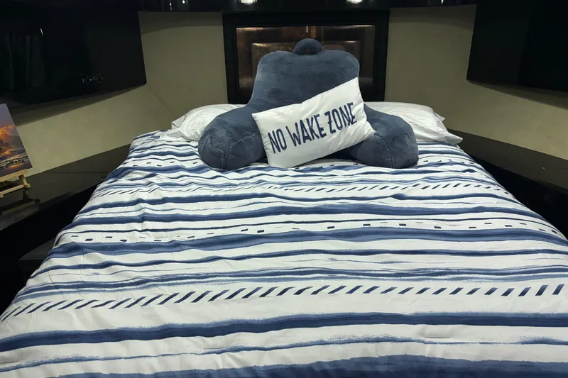 Slide: The Image of Cozy bed with striped bedding and "No Wake Zone" pillow on Maiora Phantom 1986 yacht. - 21