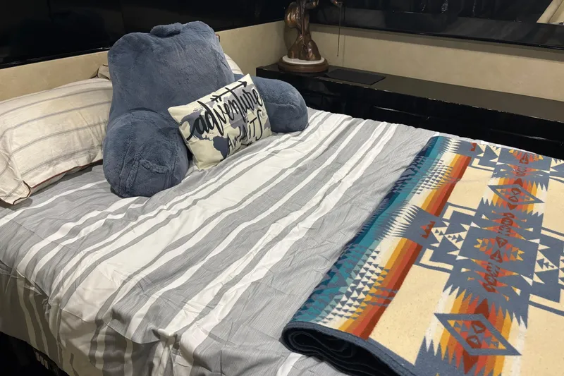 Slide: The Image of Cozy bed with striped bedding, plush pillow, and colorful geometric blanket in a Maiora Phantom 1986. - 23